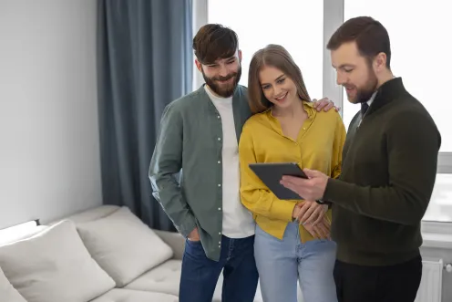 male real estate agent doing business showing house potential buying couple