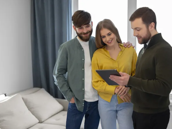 male real estate agent doing business showing house potential buying couple